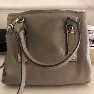 Väska  - Säljer min älskade väska i färgen ljus grå! Riktigt snygg och helt slutsåld!!!🦋den är i super bra skick inga slitningar. Den är som ny! 
