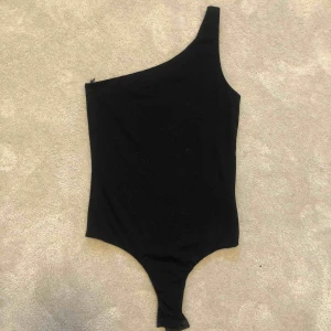  - Snygg body med en axel. Säljer för 100kr. Perfekt till fest med snygga byxor till🤍