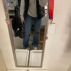 Jeans med slits och hål - Så snygga jeans med både slits och hål ifrån pull and bear. Perfekta blåa färgen som verkligen passar till allt!! Storlek 32