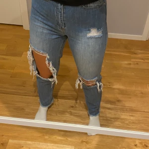 Blåa jeans med hål - (Bild på min syrra) Blåa jeans med stora hål. Ifrån riot, har inte riktigt koll på det märket men men. Storlek 36 bra skick. Frakt tillkommer