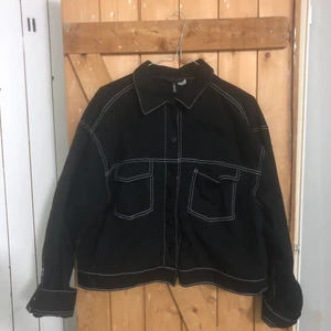 H&M jeansjacka  - Säljer en svart jeansjacka med vita kontrastsömmar från konceptet divided från H&M! Storlek 42 men sitter snyggt oversized på mig som är 34 i vanliga fall! 