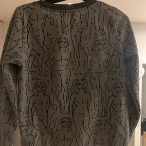 Sweater - Jättecool sweater med kvinnor på. Grå men med silverdetaljer vid halsen och armarna. Har tyvärr aldrig kommit till användning