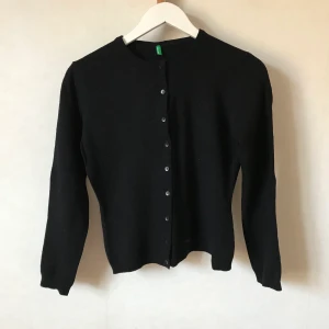 Svart kofta, Benetton, 100% ull - Underbar svart kofta från Benetton med knappar! Lappen borttagen men är helt säker detta är varm och skön 100% ull som alla andra koftor från Benetton jag haft. Litet luddig på bild pga annat ylle, men fixas inför sälj.  Kan mötas runt Stockholm/Södermalm eller skicka mot fraktkostnad! ✨🌸✨