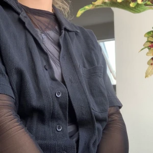 Svart kortärmad skjorta - Svart kortärmad skjorta, med tyginsläpp. Köpt second hand, snyggt urtvättat 🌵 oversized fit. •köparen står för frakten•