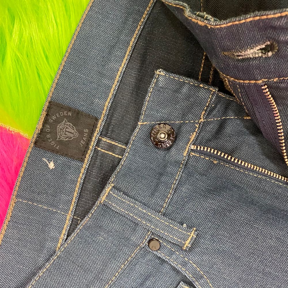 Supersnygga mörkblåa jeans från Tiger Of Sweden i nyskick. Försmå för mig. Modellen heter Style Iggy. Storlek 27/32. Mått rakt över midja 34cm. Innerbenslängd 73cm. SafePay knappen är aktiverad så det går att köpa direkt utan att behöva meddela! Tar annars swish! (Safepay tar 10% av betalningen och spårbar frakt på 66kr är inräknad i priset) Skriv gärna om du har eventuella frågor!. Jeans & Byxor.