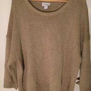  - Guldglittrig stickad tröja med breda armar. Den är lång och härlig!