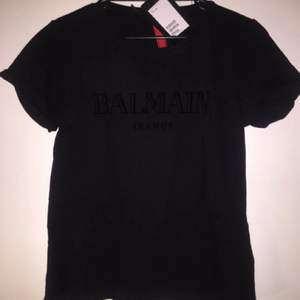 Ny HM x Balmain t-shirt i storlek M. Den är helt oanvänd med lapparna på i storlek M och är väldigt eftertraktad.
