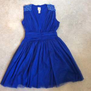 Vacker blå festklänning i tyll med detaljer av pärlor. Klänningen är i perfekt skick. Passar till bal eller fest. 