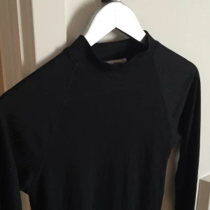  - Turtleneck svart lite längre tröja. Tunn.
