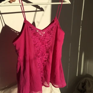 Rosa Linne  - Ett rosa linne med spagetti band. Jag älskar tyggen som bryter i ett mesh material. Pris: 80kr 