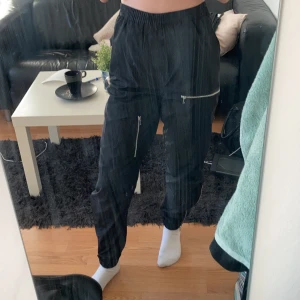 Streetiga byxor från bikbok - Svarta byxor i coolt material och med dragkedjor som detaljer! Säljer då de inte riktigt är min stil längre. Frakt tillkommer på 59kr, men kan även mötas upp i Gävle!