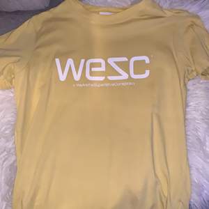 Gul WeSC T-shirt med tryck på framsidan. Använd fåtal gånger.