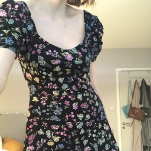 Kort klänning - Jätte söt klänning från H&M. U-ringad kort klänning med mönster av fåglar och blommor. Går ner i ryggen och har puffaxlar. Nyskick. Köpt i sommras. Storlek M men passar S.