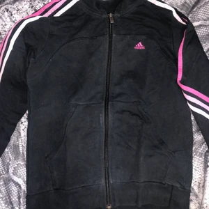 Retro Adidas kofta - Svart adidaskofta med rosa tryck, motsvarar XS/S. Snygg för dig som vill ha en ”tajtare/kortare” look. Kan mötas upp eller fraktas, köpare står för frakt