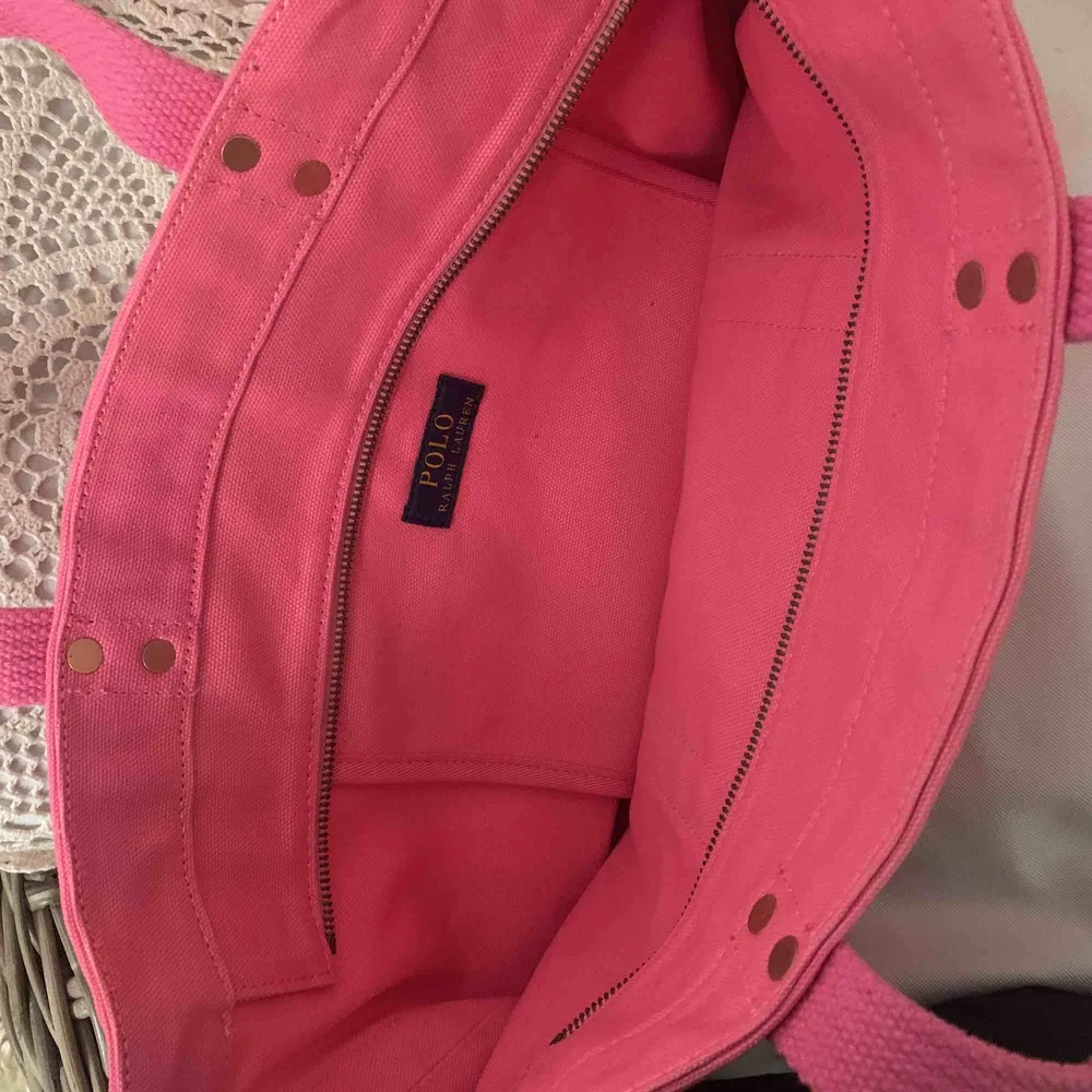 Denna väska är en Original Ralph Lauren Tote Bag i färgen rosa. Perfekt som en lyxig skolväska, strandväska eller shoppingbag då den är rymlig men ändå inte så jätte stor! Original pris ligger på 995 kronor. Denna är endast använd en gång.. Väskor.