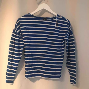  - Vanlig blå och vit randig tröja, ärmen är lite kortare och piffig på, ganska tunn i materialet 