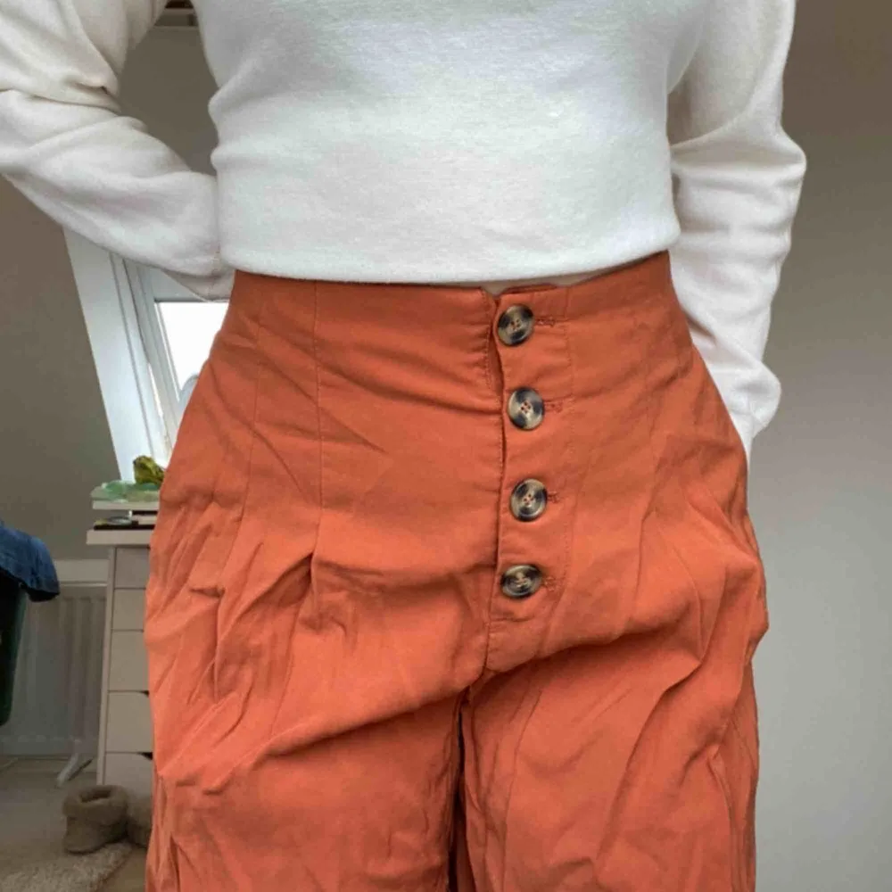 Vida orangea byxor från Zara med brunspräckliga knappar framtill. Lite kortare än vanliga byxor. Använda endast en gång. Säljer pga av att de inte kommer till användning. Frakt tillkommer.💕💕💕💕💕. Jeans & Byxor.