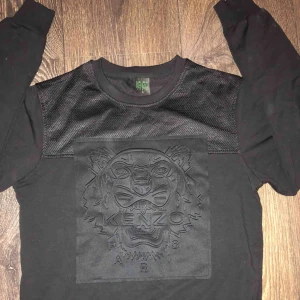  - En svart Kenzo tröja som är lite over size, är lite längre där bak och har två dragkedjor på sidorna. Köpt för lite över två år men använd bara två gånger är dessutom i jätte bra skick.