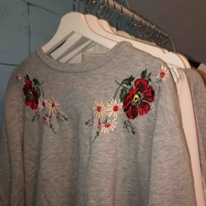  - Basic grå sweather från strandivarius med brodyr över bröstet