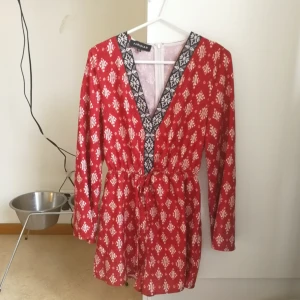  - Röd jumpsuit som knyta i midjan. 