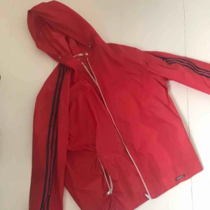  - Röd vind/regn jacka från adidas. Väldigt bra skick och nästan inte använd alls! Köparen står för frakt men möts kan mötas upp i Stockholm<3