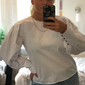 Skjorta med puffärm - Supersnygg skjorta med puffärm och svarta knappar. Sparsamt använd och i fint skick. Storlek 40 men passar snarare 36-40. Har ni frågor eller funderingar är det bara att höra av sig. Köparen står för frakt 🚚.