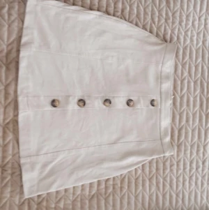 Beige knappkjol - Superfin beige knappkjol i mockaliknande material. 