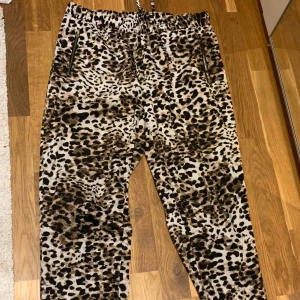  - Avslappnade och svala tunna byxor från Lindex i glansigt material. Dragkedjor på fickorna i sidan och dragsko i midjan. Något avsmalnade benslut.