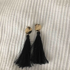  - Jättefina örhängen med guld detaljer och svarta fransar