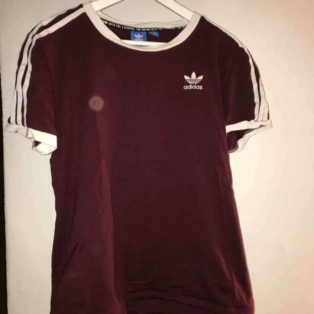 Adidas T-shirt som är vinröd typ. Aldrig använd. (Ej fläckar bara ljuset). T-shirts.