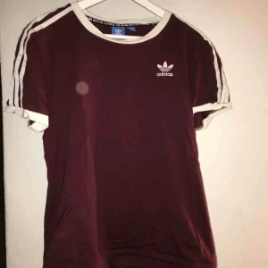  - Adidas T-shirt som är vinröd typ. Aldrig använd. (Ej fläckar bara ljuset)