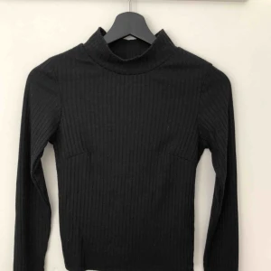  - Svart långärmad topp med turtleneck. Går att vika net kragen om man tycker den är för hög!