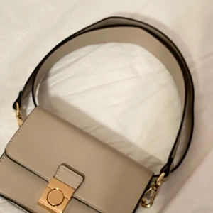 Axelväska  - Fin oanvänd mini väska, har långt band, men kan användas som en axelväska också)) köpt på Åhléns!