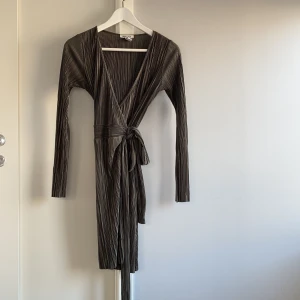 Mörkgrön omlottklänning från nelly - Använd en enstaka gång så i fint skick! Köparen står för frakten!