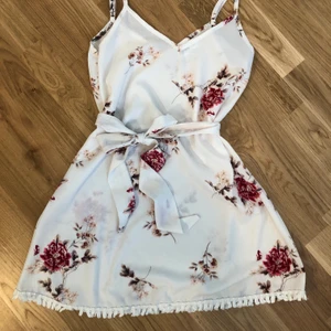 Klänning från DM retro - Super fin sval klänning från DM retro i fint skick med tillhörande skärp. Tunt vitt tyg med rosa blommor. Passar en xs-s. Jag är 160cm❤️