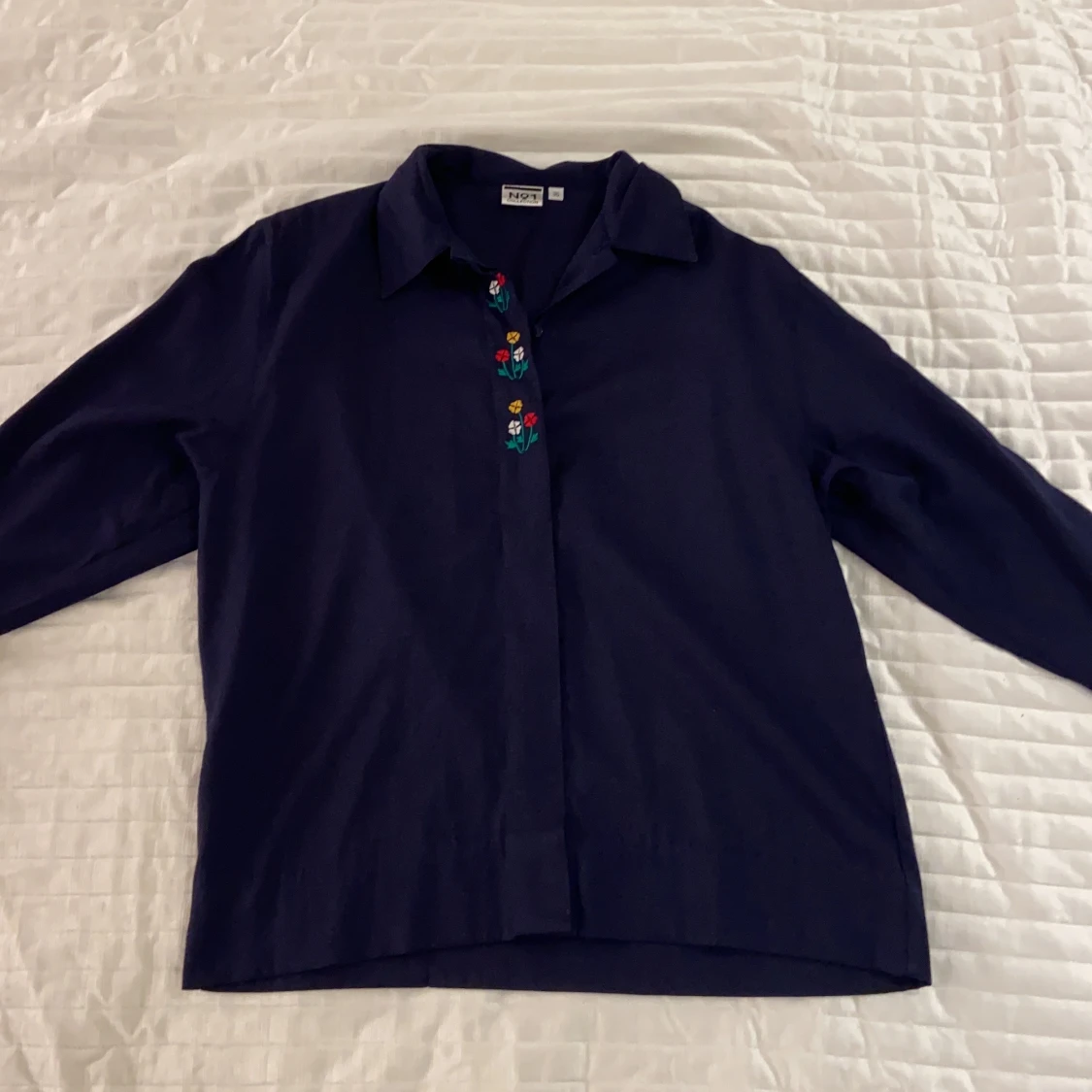 Mörkblå skjorta med broderade blommor