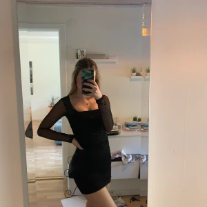 Helt ny snygg klänning - Lapp finns kvar. Svart klänning som är genomskinliga på armarna. 