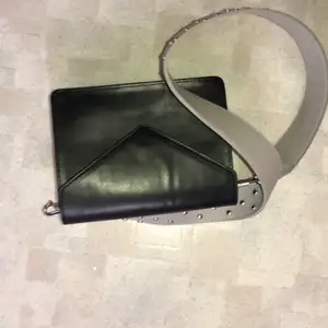 En svart crossbody väska från Pieces med ett snyggt grått band med nitar.