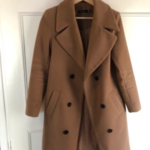 Brun kappa - Säljer denna jätte snygga bruna höstkappa med svarta prydnads knappar. Jackan går ej att knäppa men snygg att bara ha såhär öppen med något varmt under. Köpt från Bohoo för ett år sedan🖤 Köparen står för frakten! 