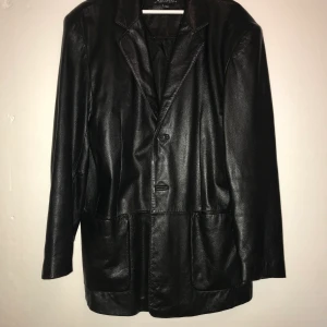 Skinnjacka - Trendig svart skinnjacka i äkta skinn. Storleken är L men sitter mer som en XL. Skön oversized fit.