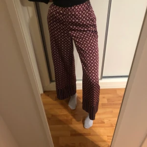 Mönstrade Finbyxor strl 38  - mönstrade silkiga finbyxor från kappahl med liten dragkedja i midjan i strl 38. Jag säljer då de är för stora för mig. Tror de passar S/M. Aldrig använda. Frakt på 45 kr tillkommer  