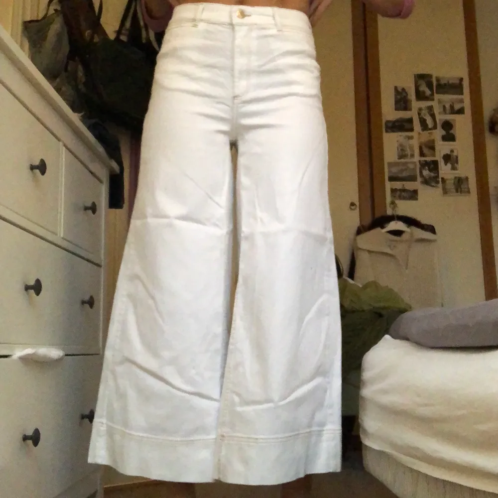 Jättefina vita, vida jeans med ljusbruna sömmar som aldrig använts. De är korta i modellen och går till anklarna 🤍. Jeans & Byxor.