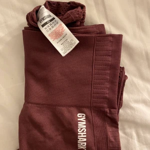 Gym shark energy+seamless leggings - Säljer nu mina skitsnygga och supersköna träningstights från Gym shark i färgen berry red, de kommer tyvärr inte till användning längre😩Superbra skick då de är använda Max 20 ggr, märket på vänster höft och bak börjat spricka lite i trycket💕 Nypris: 600kr