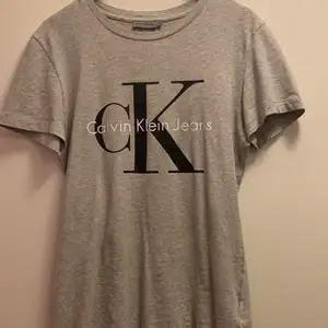 En grå Calvin Klein T-shirt i toppskick så den endast används cirka 2-3 gånger. Materialet är väldigt mjukt och skönt, ordinariepris 350kr. (Kunden står för frakt)