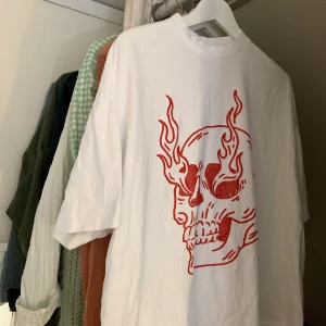 Vit T-shirt med dödskalletryck - Lägger upp denna på nytt då så många budat men utan tydliga svar om de kommer köpa eller ej. Budet låg då på 270kr men jag startar den nya budningen på 200kr. Vi tar buden i kommentarerna denna gång💕  (bara att fråga om fler bilder om de önskas och se gärna tidigare inlägg för mer info om tshirten) höj med minst 10kr.             AVSLUTAR 23/11 KL 12:00 