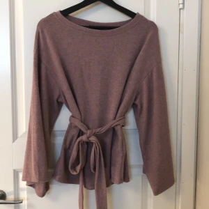 Tröja med knytning i midjan  - Söt tröja med knytning i midjan och vida ärmar. Väldigt stretchig och mysog i materialet. Passar s-M/L