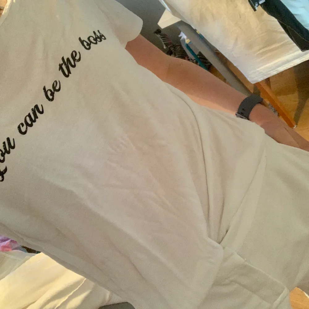 Säljer denna vit t-shirt med en svart text på. Asnygg till sommaren med ett par shorts eller jeans.. T-shirts.