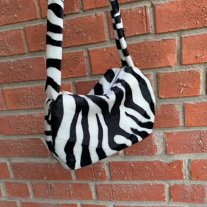 Supersöt zebraväska!! - Tillverkad av mig med blixtlås. Jag strykte in ett foder för att göra väskan med stabil, så den är mer hård än den andra väskorna jag säljer! Därav priset. Jag har 3 i lager❤️❤️❤️ 