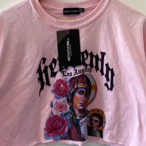 Oversized croptop från PLT! - Snygg Oversized rosa croptop från PrettyLittleThing! Endast provat, och har därför några smink fläckar runt halsen som jag inte har försökt få bort. Skitcool print! Står storlek 40 men passar 38-42 beroende på hur man vill att den ska sitta :)