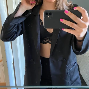 Blazer - Så fin svart blazer i ett lite glansigare material, aldrig använd och nypris 599kr!!!! Funkar över byxa och i sig själv, dock kan den vara lite kort. 